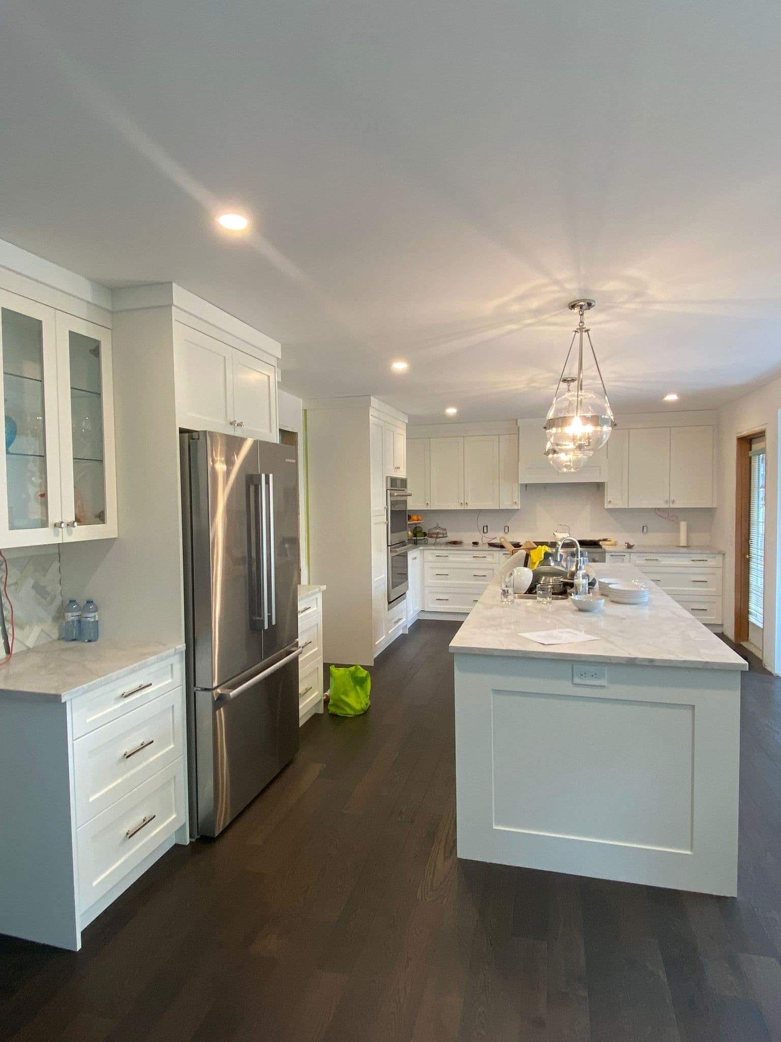 Custom white flat-panel kitchen cabinets with waterfall island by YYC Cabinets Calgary
