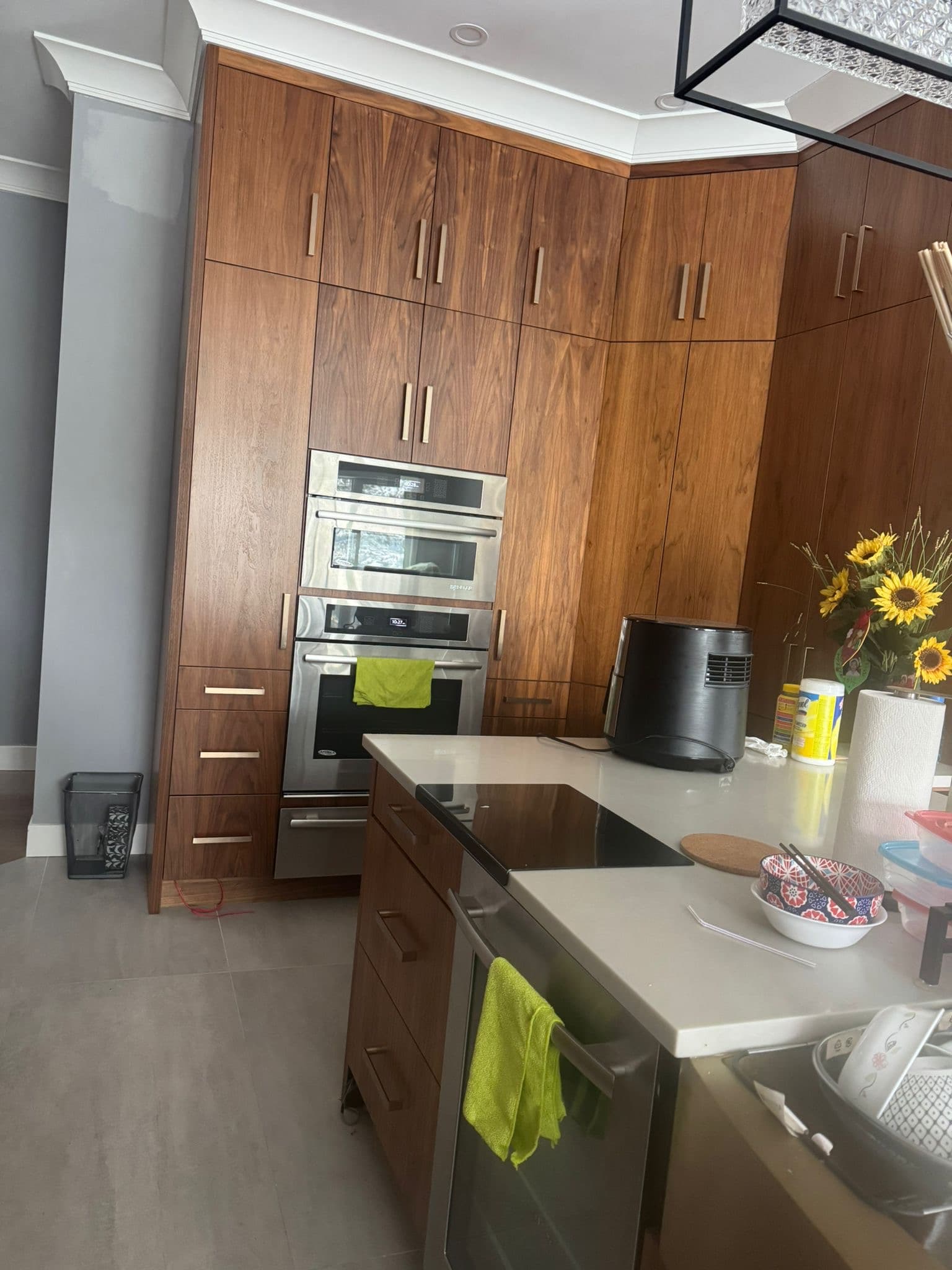 Modern kitchen corner with dark wood custom cabinets and built-in ovens by Calgary custom cabinets.