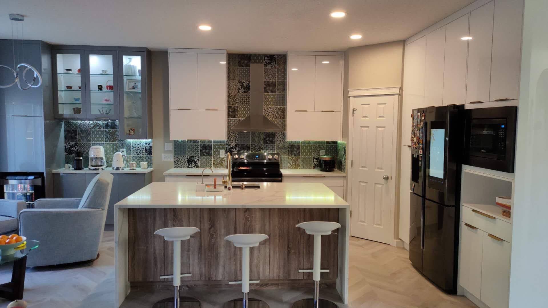 Vibrant kitchen with glossy white and light wood flat-panel Calgary custom cabinets, unique patterned backsplash, island seating, and black smart refrigerator.